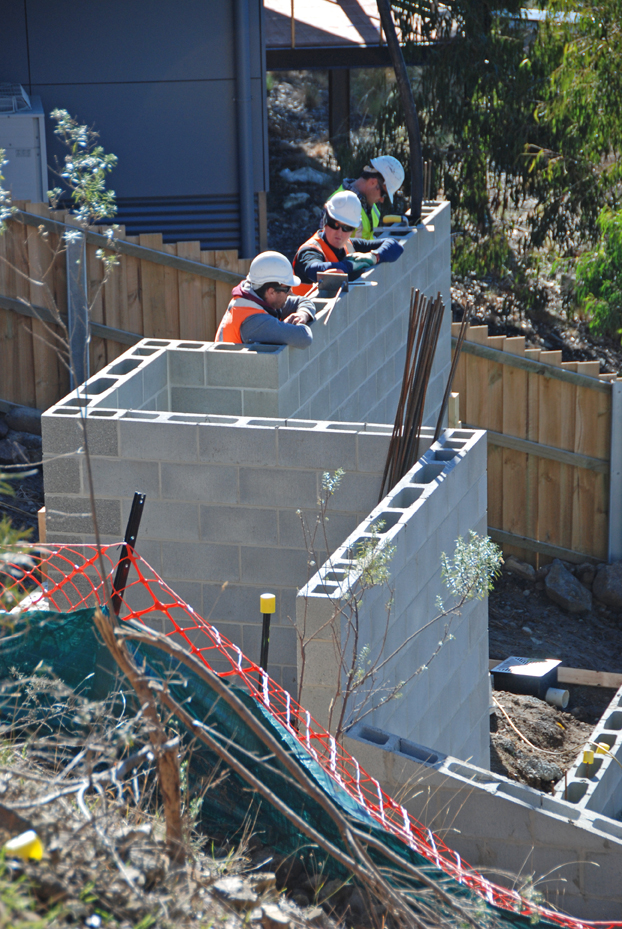 The merry band of carpenters-plus – today concreters and finishers – Nathan (left), Jib and Damien (right) waits. The small-diameter boom hose, looking like an elephant's trunk, sits inside a block next to Damien.